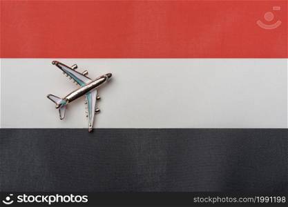 The plane over the flag of Yemen, the concept of travel. Toy plane on the flag as a background.. The plane over the flag of Yemen, the concept of travel.