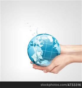 The Planet. Globe in human hand against blue sky. Environmental protection concept. Elements of this image furnished by NASA
