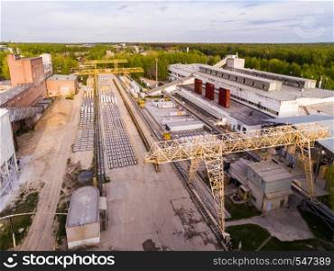 The plant was built in Soviet times, but still performs its basic functions. Old asphalt and concrete plant, with large metal structures. Aerial view