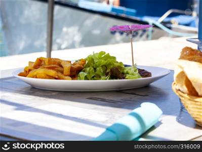 The plate of traditional schnitzel with potato fries on restorant