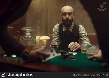 The poker players in casino, blackjack. Games of chance addiction, gambling house. Men leisures with whiskey and cigars, gaming table with green cloth. The poker players in casino, blackjack