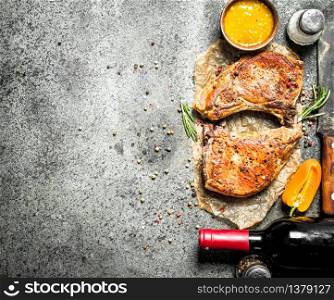 The pork steak with spices. On rustic background.. The pork steak with spices.