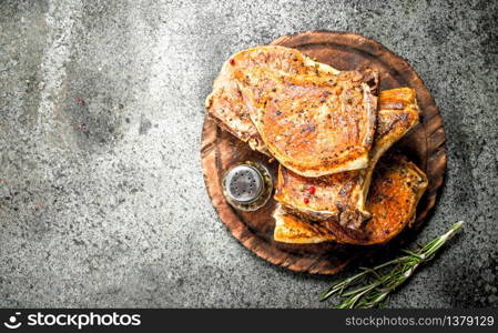 The pork steak with spices. On rustic background.. The pork steak with spices.