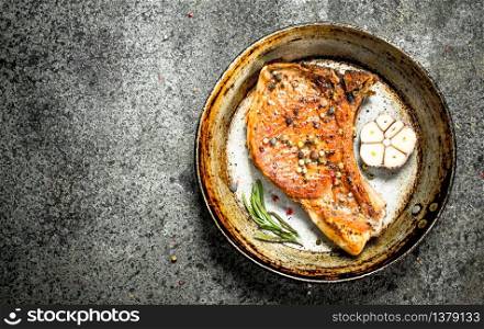 The pork steak with spices. On rustic background.. The pork steak with spices.