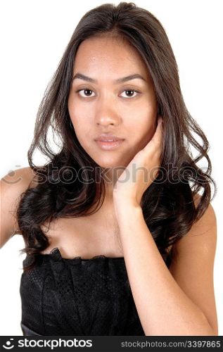 The portrait of a beautiful Asian woman with long curly brunette hairholding one hand on her face, in a black dress over white.