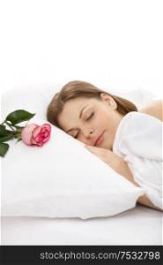 The portrait of the girl sleeping in bed, on a pillow lies a rose