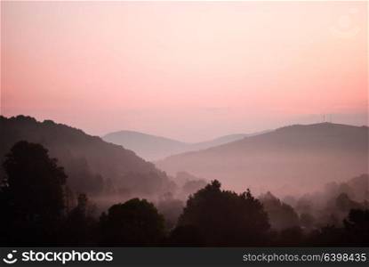 The predawn hour in mointans. View from the peak on the village. Morning fog in moutnains