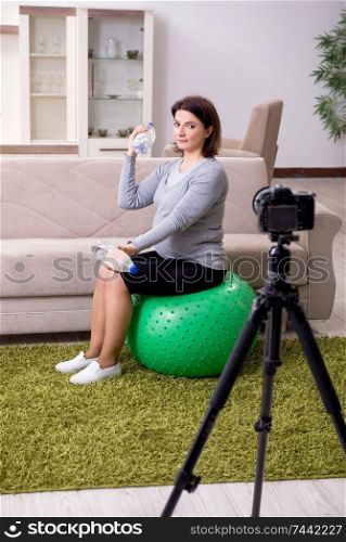 The pregnant woman blogger doing physical exercises . Pregnant woman blogger doing physical exercises 