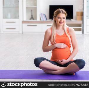 The pregnant woman doing sport exercise at home. Pregnant woman doing sport exercise at home