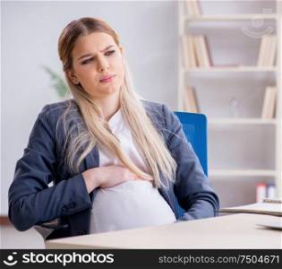 The pregnant woman employee in the office. Pregnant woman employee in the office