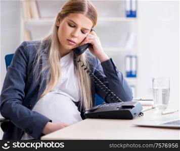 The pregnant woman employee in the office. Pregnant woman employee in the office