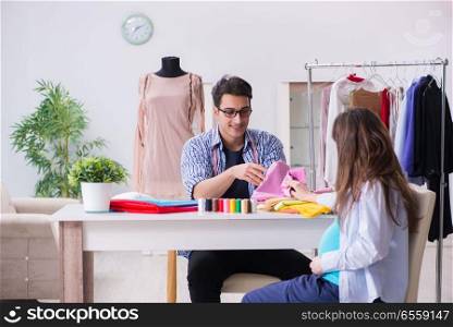 The pregnant woman visiting tailor for new clothing. Pregnant woman visiting tailor for new clothing. The pregnant woman visiting tailor for new clothing