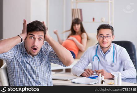 The pregnant woman with her husband visiting the doctor in clinic. Pregnant woman with her husband visiting the doctor in clinic