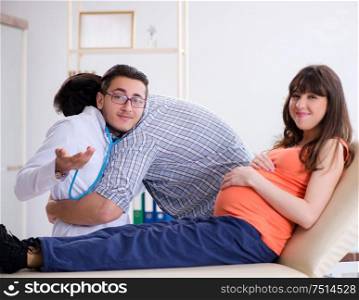 The pregnant woman with her husband visiting the doctor in clinic. Pregnant woman with her husband visiting the doctor in clinic
