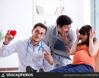 The pregnant woman with her husband visiting the doctor in clinic. Pregnant woman with her husband visiting the doctor in clinic