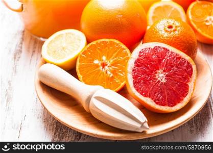 The preparation for citrus juice for breakfast. Wooden citrus reamer with fruits.. Tangerine juice