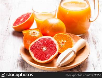 The preparation for citrus juice for breakfast. Wooden citrus reamer with fruits.. The citrus juice