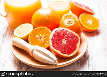 The preparation for citrus juice for breakfast. Wooden citrus reamer with fruits.. The tangerine juice