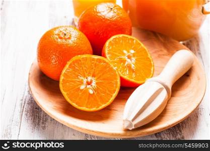 The preparation for tangerine juice for breakfast. Wooden citrus reamer with fruits.