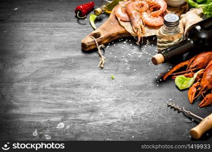 The preparation of fresh seafood. Wine with spice and fresh shrimp, lobster. On a black chalkboard.. Wine with spice and fresh shrimp, lobster.