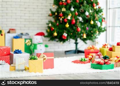 The present or gift boxes are set up in the room with Christmas tree as decoration for the celebration of festival at home.