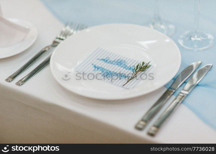 The presidium of the newlyweds in the banquet hall of the restaurant is decorated with candles and green plants, wisteria hangs from the ceiling