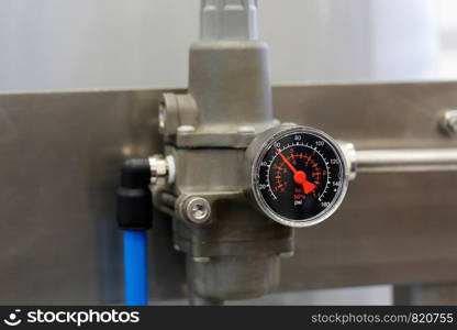 The pressure gauge measuring pressure in the system.