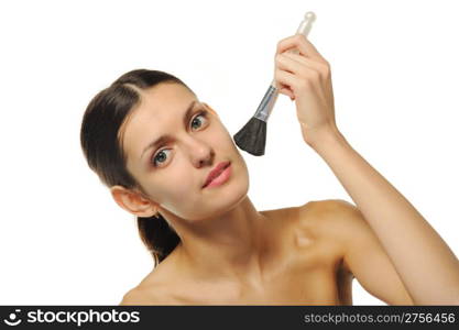 The pretty woman with a brush for a make-up. It is isolated on a white background.