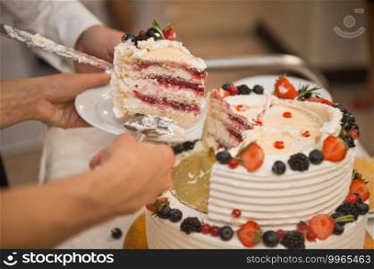 The process of cutting a delicious birthday cake decorated with flowers from edible materials.. Newlyweds cut birthday cake 2174.
