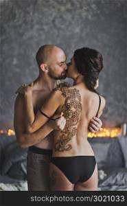 The process of exposure of a female back tattoo.. The man removes clothes from girls 213.