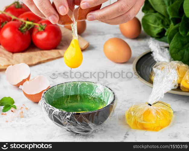 The process of making poached or benedict eggs. The cook pours an egg into a plate. Ingredients for making breakfast on the table. close-up, shallow depth of field. The idea of cooking.
