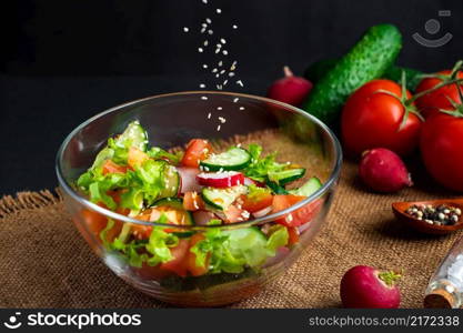 The process of preparing vegetable salad. Seasonal summer dish, vegetarian food on a black background.. The process of preparing vegetable salad. Seasonal summer dish, vegetarian food on black background.