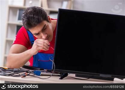 The professional repair engineer repairing broken tv. Professional repair engineer repairing broken tv