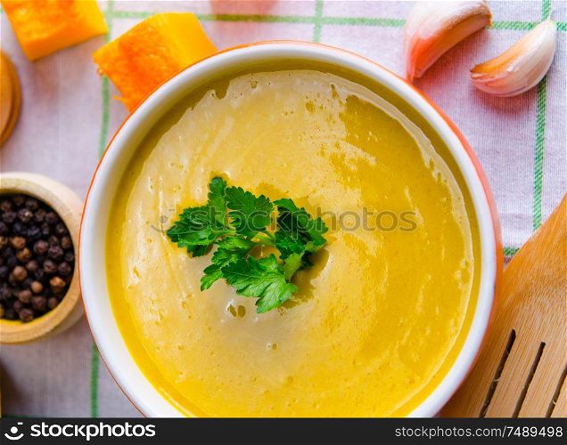 The pumpkin soup served on the table in bowl. Pumpkin soup served on the table in bowl