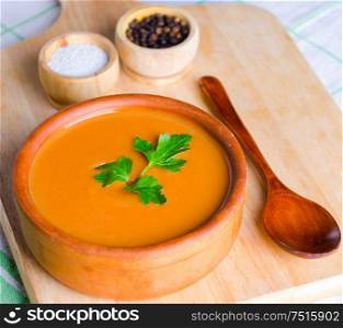 The pumpkin soup served on the table in bowl. Pumpkin soup served on the table in bowl