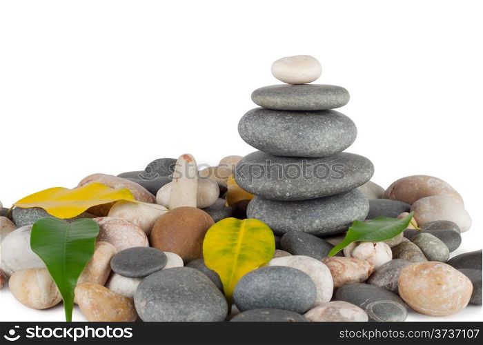 The pyramid of round stones with leaves isolated on white background