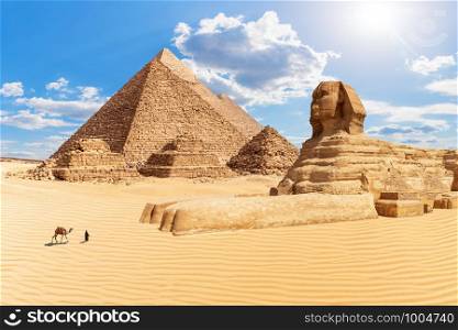 The Pyramids and the Sphinx in the sunny desert of Giza, Egypt.. The Pyramids and the Sphinx in the sunny desert of Giza, Egypt