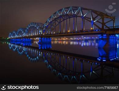 The Railway Bridge in Riga at night with beautiful reflections in Daugava river