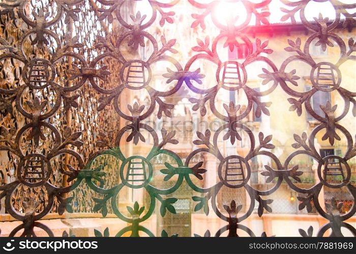 The rays of sun through forged lattice fence Scaliger Tombs in Verona, Italy