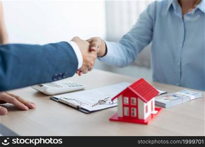 The real estate concept the house estate and his client shaking hands for accepting to make the land sale contract.