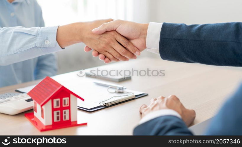 The real estate concept the house estate and his client shaking hands for accepting to make the land sale contract.