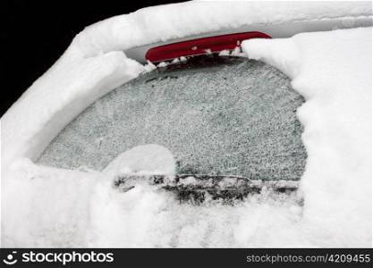 The rear screen of a car covered with ice and snow