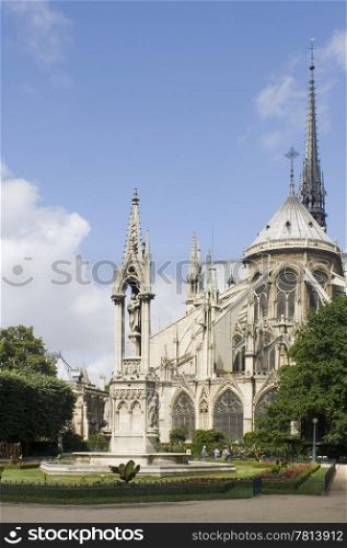 The rear side of the Notre Dame Cathedral in Paris with it&rsquo;s beautiful and tranquil garden, just catching the sunlight. The blue sky can very well be used as copyspace