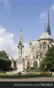 The rear side of the Notre Dame Cathedral in Paris with it&rsquo;s beautiful and tranquil garden, just catching the sunlight. The blue sky can very well be used as copyspace
