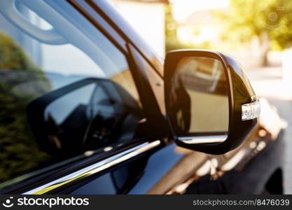 The rear view mirror on modern car on a black car. Rear view mirror car on the road. Close-up of Road safety while driving. The rear view mirror on modern car on a black car. Rear view mirror car on the road. Close-up of Road safety while driving.