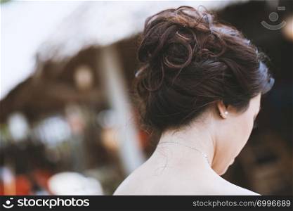 The rear view of young Asian bride with fashion hairstyle middle bun with black-brown hair