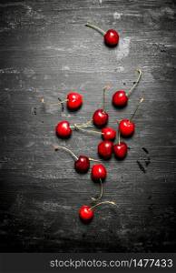 The red cherry . On a black wooden background.. The red cherry .