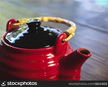 The red chinese teapot on a wooden table, close-up