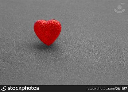 The red heart shape on dark grey glitter background in love concept for valentines day. Copy space