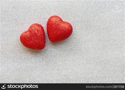 The red heart shapes on silver glitter paper background in love concept for valentines day. Copy space